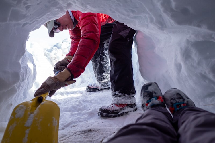 Polar Bears International staff member BJ Kirschhoffer shown excavating an artificial den for the SAR test