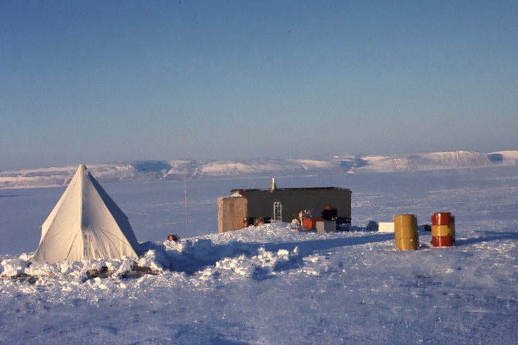 A cliff-side observation cabin and sleeping tent on Cape Liddon, Devon Island, in spring.